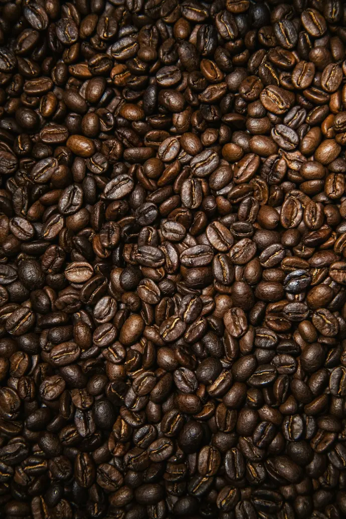 brown coffee beans on black surface
